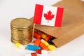 Expensive Medicine in Canada. Closeup brown bag with pills falling out, high cost, expensive healthcare Royalty Free Stock Photo