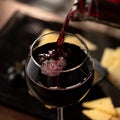 Expensive Red wine pouring into wine glass. Wineglass with merlot or sauvignon on Blurred background. Close up shot