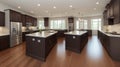 Kitchen in new luxury home with quartz waterfall island, hardwood floors, dark wood cabinets, and stainless steel appliances. Royalty Free Stock Photo