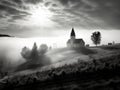 A small church in the countryside on a foggy morning with beautiful sunlight in front, black and white photo - generative ai