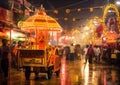 a carnival with a cart and a carousel in the rain at night time with people walking around Royalty Free Stock Photo