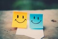 Positive attitude concept, one yellow and blue color smiling sticky note emojis, happy face.