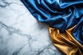 Exquisite Blue and Gold Fabric Drape on a Marble Platform A Luxurious Flat Lay for Design Inspiration Royalty Free Stock Photo
