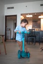 Tiny explorer: Cute toddler's blue push scooter adventures at home