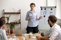 Experienced ambitious businesswoman gives presentation at team meeting near flipchart Royalty Free Stock Photo