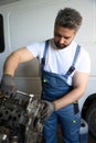 Experienced automotive technician fixing car engine in repair shop