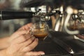 Closeup of barmen hand brewing espresso in professional coffee machine