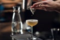 An experienced bartender prepares an alcoholic cocktail. No face, close-up, copy space.