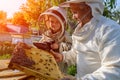 Experienced beekeeper grandfather teaches his grandson caring for bees. Apiculture. The transfer of experience. Royalty Free Stock Photo