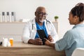 Experienced black doctor explaining treatment plan to female patient Royalty Free Stock Photo