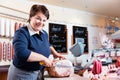 Experienced butcher shop assistant cutting ham Royalty Free Stock Photo