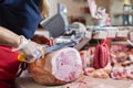 Experienced butcher shop assistant cutting ham Royalty Free Stock Photo