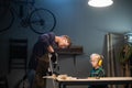 An experienced carpenter shows the work of various tools to his son in the workshop. Royalty Free Stock Photo