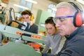 Experienced carpenter teaching two teenage boys Royalty Free Stock Photo