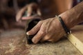 Experienced carpenter in work clothes. small business owner working in woodwork workshop, using sandpaper for polishing Royalty Free Stock Photo