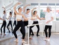 Experienced choreographer teaches ballet dancers movements at ballet barre in choreographic studio Royalty Free Stock Photo