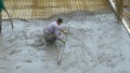 CLOSE UP: Experienced contractor spreads fresh concrete covering the ground.