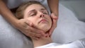 Experienced cosmetologist making girl relaxing face massage, treatments