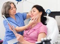 Experienced cosmetology doctor examines a young woman patient before the procedure