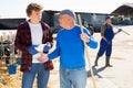 Experienced dairy farm owner teaching young worker