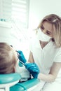 Experienced dentist examining her little patient carefully