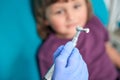 Experienced doctor preparing for polishing of female child tooth enamel