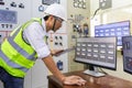Experienced electrician working in a power plant control room. Engineer working in electric power distribution substation checking Royalty Free Stock Photo