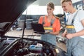 Experienced female auto mechanic checking the engine error codes Royalty Free Stock Photo