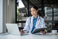 An experienced female doctor is working at her desk in the hospital, reading medical reports online Royalty Free Stock Photo