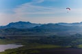 Experienced hang-glider hovering above hilly landscape