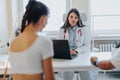 An experienced doctor advises a couple at a health clinic, discussing clinical outcomes and treatment options using