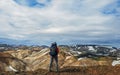 Experienced hiker woman with heavy huge backpack standing and looking at rhyolite mountains Landmannalaugar Iceland Royalty Free Stock Photo