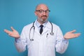 Experienced male doctor standing with open arms asking so how. Royalty Free Stock Photo