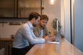 Young man analyse electronic report mistakes with skilled male colleague