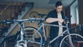 Experienced master is checking and repairing bicycle handle-bar with special tools while working in workshop with Royalty Free Stock Photo