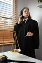 Experienced mature female lawyer standing in her office and talking on mobile phone with her clients for providing law Royalty Free Stock Photo