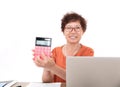 An experienced middle-aged female accountant sitting at the desk happily showing the calculator in hand