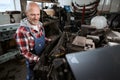 Experienced middle-aged worker is making car repairs