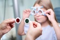 Experienced optometrist conducting duochrome test on little patient