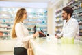 Experienced pharmacist counseling female customer in pharmacy Royalty Free Stock Photo