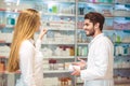 Experienced pharmacist counseling female customer in pharmacy