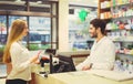 Experienced pharmacist counseling female customer in pharmacy Royalty Free Stock Photo