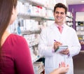 Experienced pharmacist counseling female customer