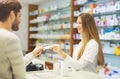 Experienced pharmacist counseling male customer in pharmacy