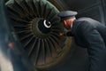 Experienced pilot inspecting the turbofan engine before the flight