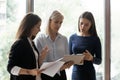 Three serious diverse businesswomen using tablet application do common work