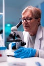Experienced scientist engineering healthcare blood sample using microscope