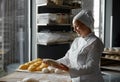 Experienced skilled woman baker forming baguettes working in bakery