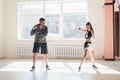 An experienced trainer puts the technique of blows to a young girl in the boxing hall Royalty Free Stock Photo