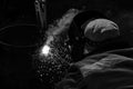 An experienced welder at work. Preparation and welding process of cast iron furnace. Selection focus. Shallow depth of field. Royalty Free Stock Photo